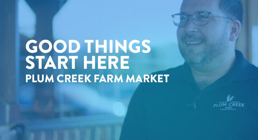 A smiling bearded man with glasses and a company shirt that says "Plum Creek" with text overlaid that reads "Good things start here. Plum Creek Farm Market".